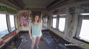 Nailing a buxom teenager to the wall in a mostly gray railway car